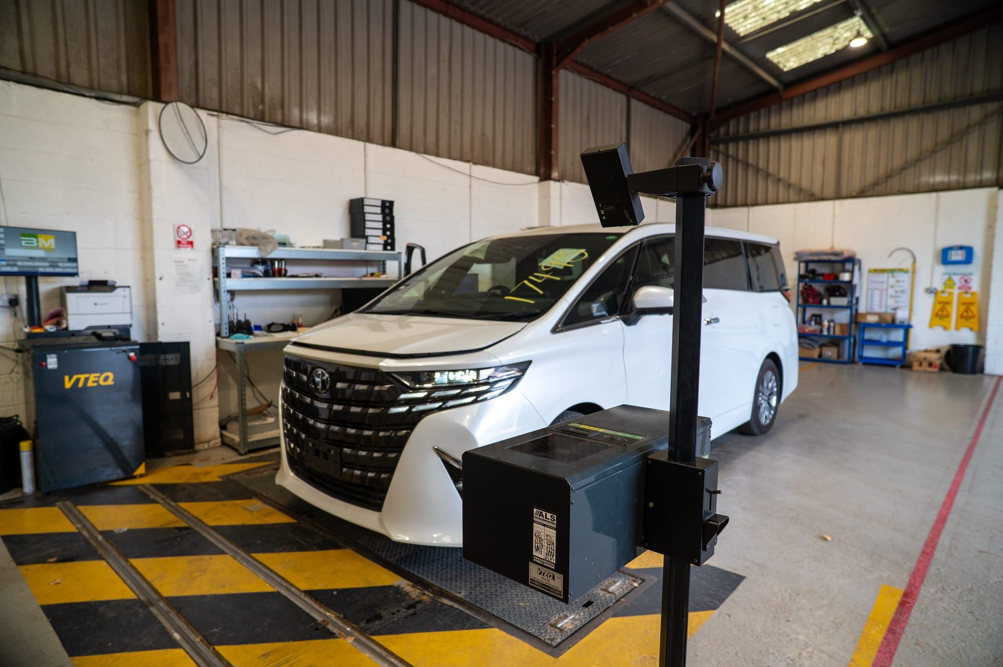 A white Toyota Alphard on the brake tester in My Car Import's test lane