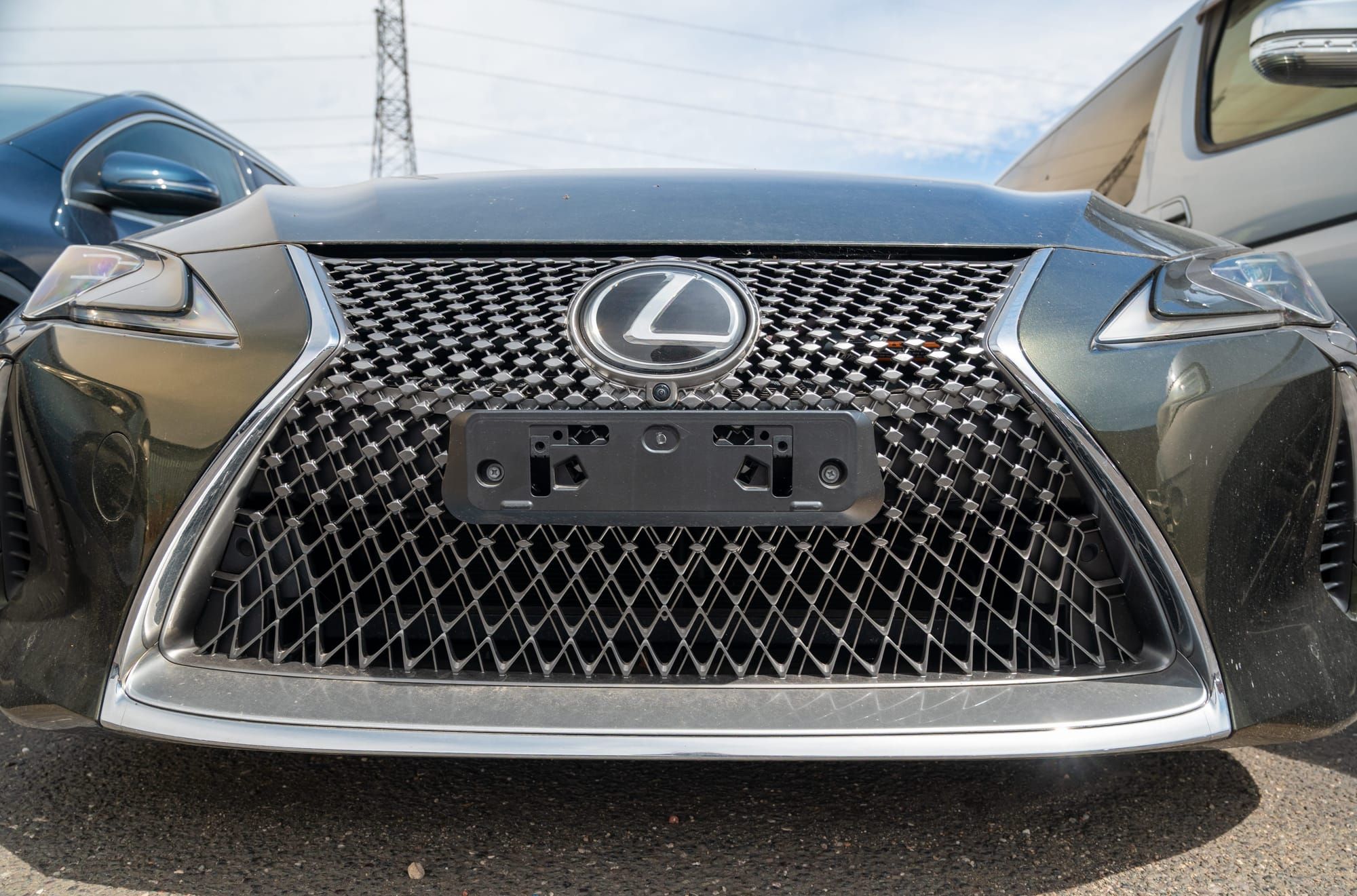 The mesh grille and badge of a grey Lexus saloon