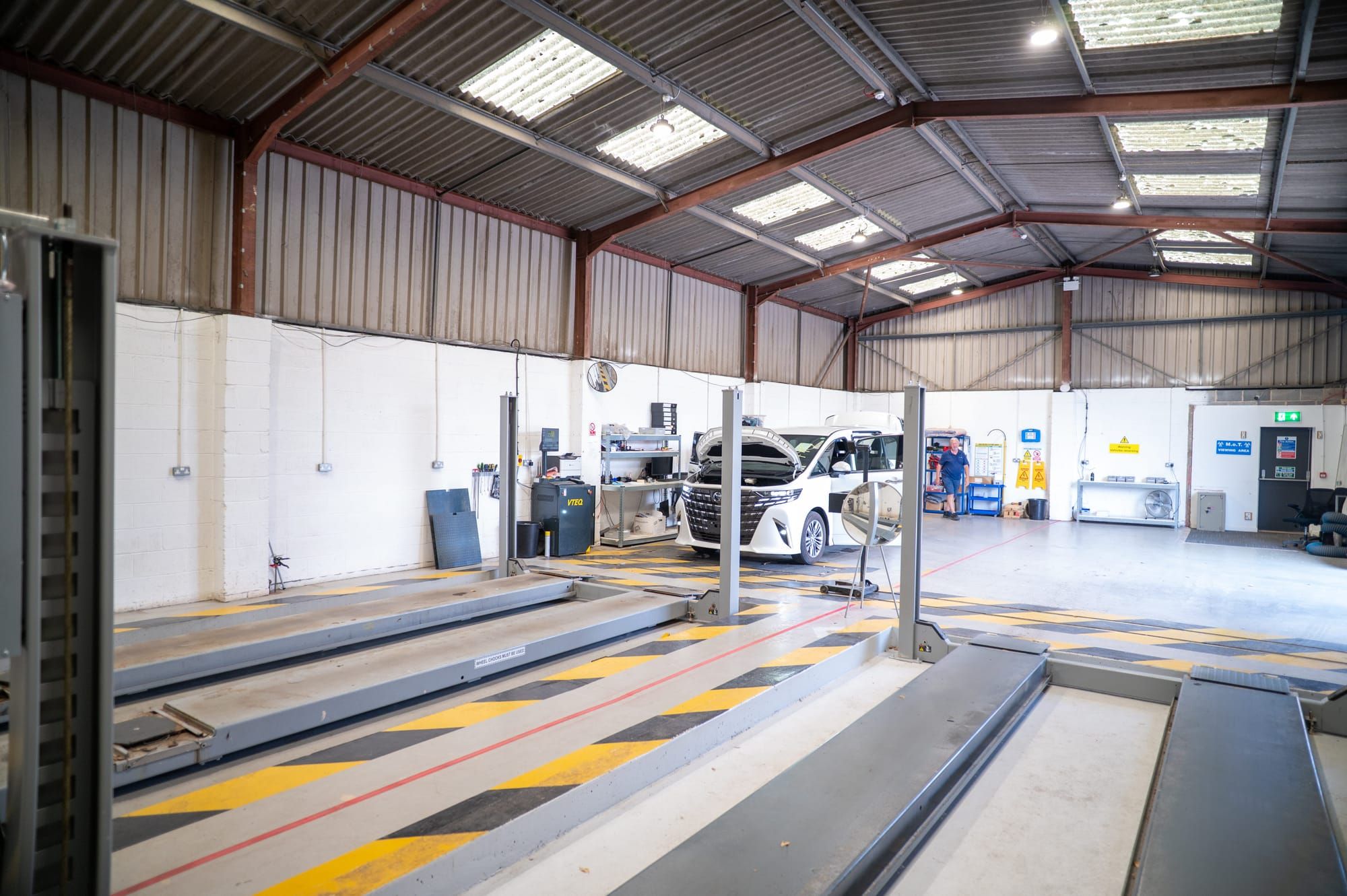 My Car Import's workshop, with yellow-hatched test lanes, lifts and a white MPV being checked