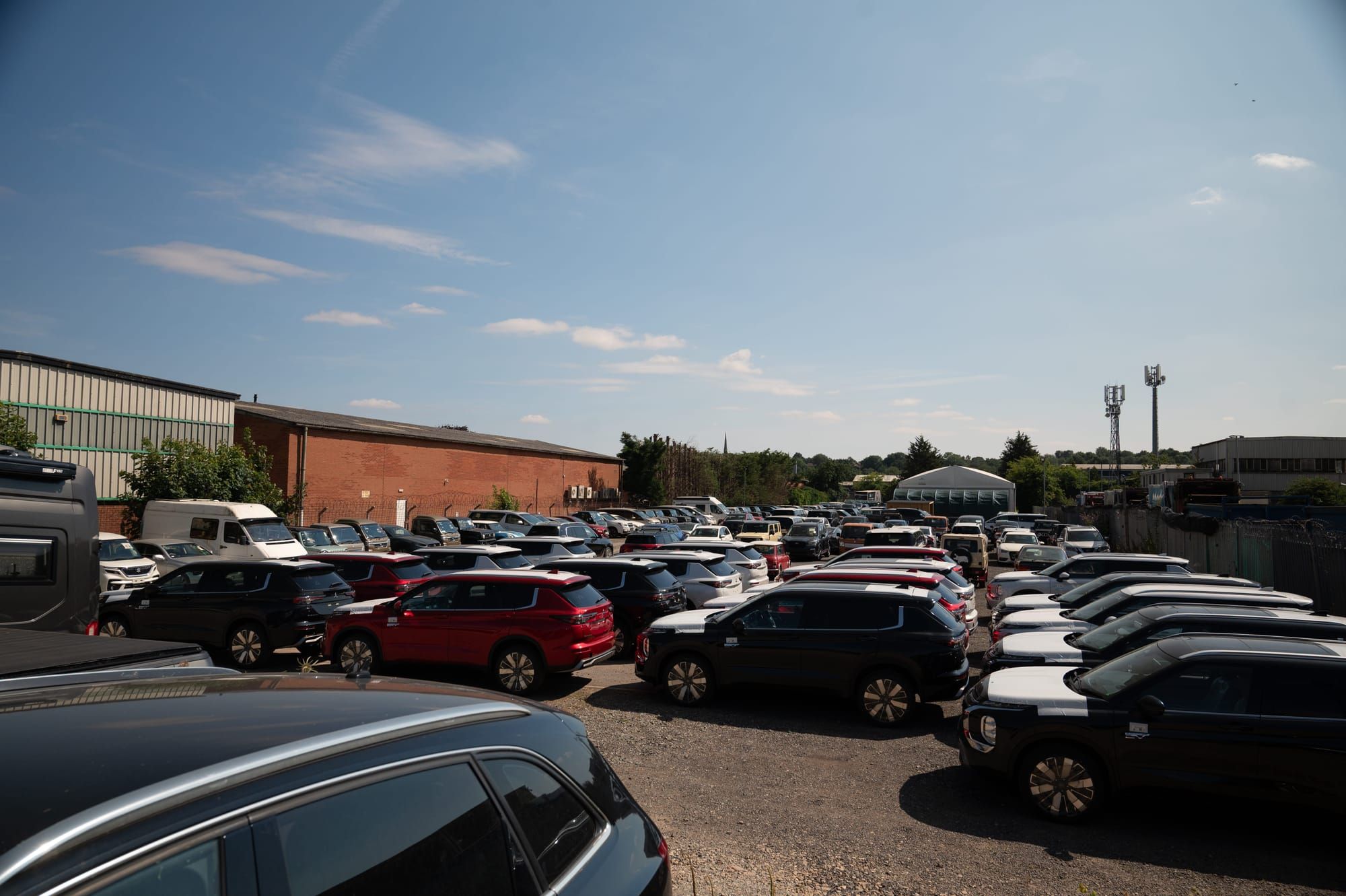 Rows of imported cars parked across My Car Import's yard on a sunny day